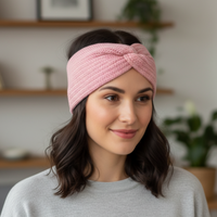 Woman wearing a pink knitted headband in a home setting